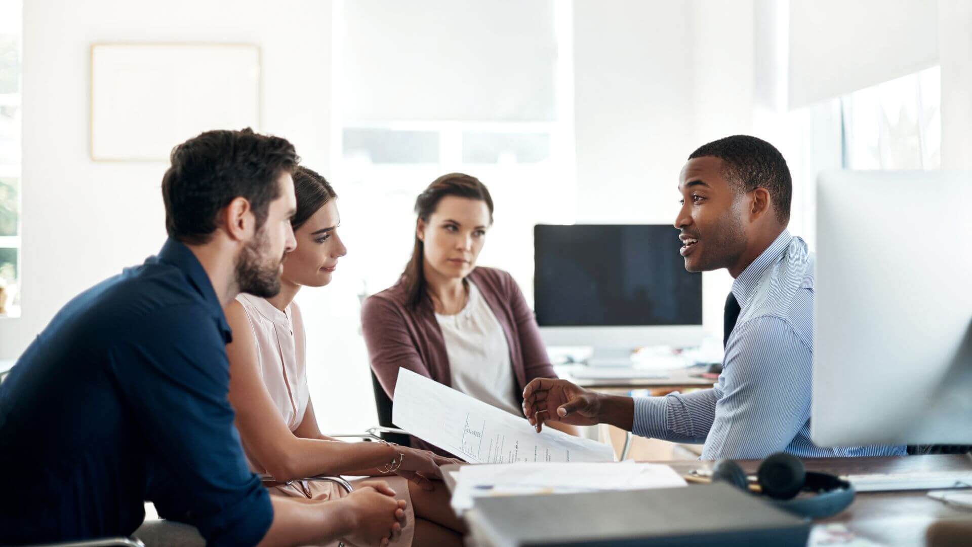 Grupo de pessoas discutindo em um escritório qual nome escolher para o negócio.